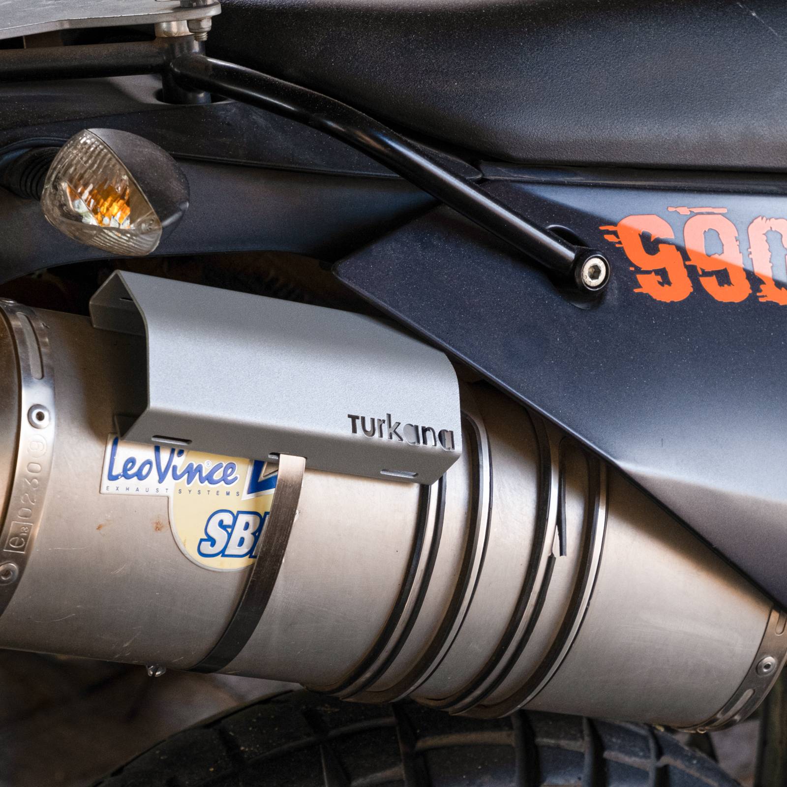 150 mm Turkana Gear stainless steel exhaust heat shield for enduro and dual sport bikes, with dual clamps to protect soft luggage from exhaust heat.