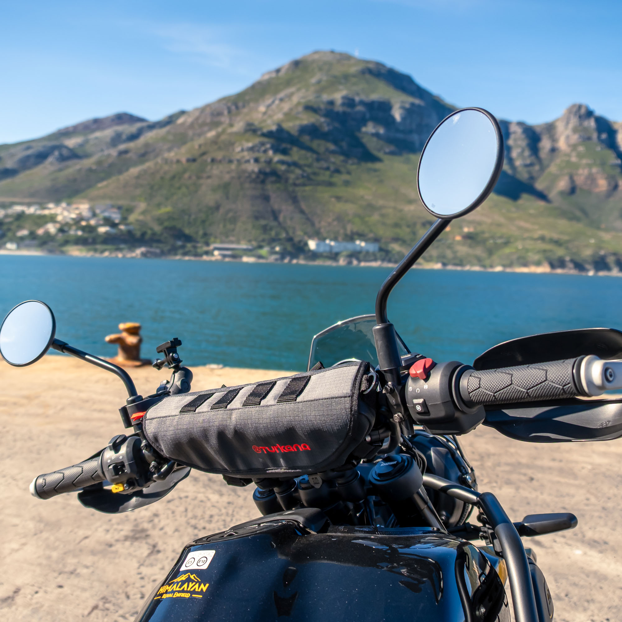 Adventure motorcycle with a Turkana Gear PelliPouch Premium handlebar bag, photographed at Chapman’s Peak with mountains and ocean in the background.