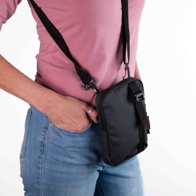 Person wearing the black Turkana SlingThing pouch horizontally on the hip, showing the back strap panel and slim profile.