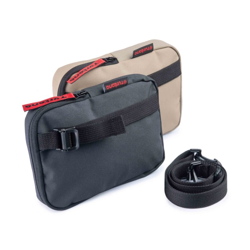 Two Turkana SlingThing pouches in sand and black color options with detachable straps placed next to them.