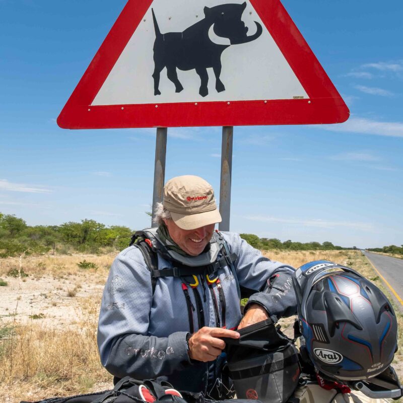 Turkana DustDevil Cap in tan with red embroidered logo and a military-style foldable design.