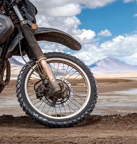 Rugged adventure motorcycle riding through remote off-road terrain